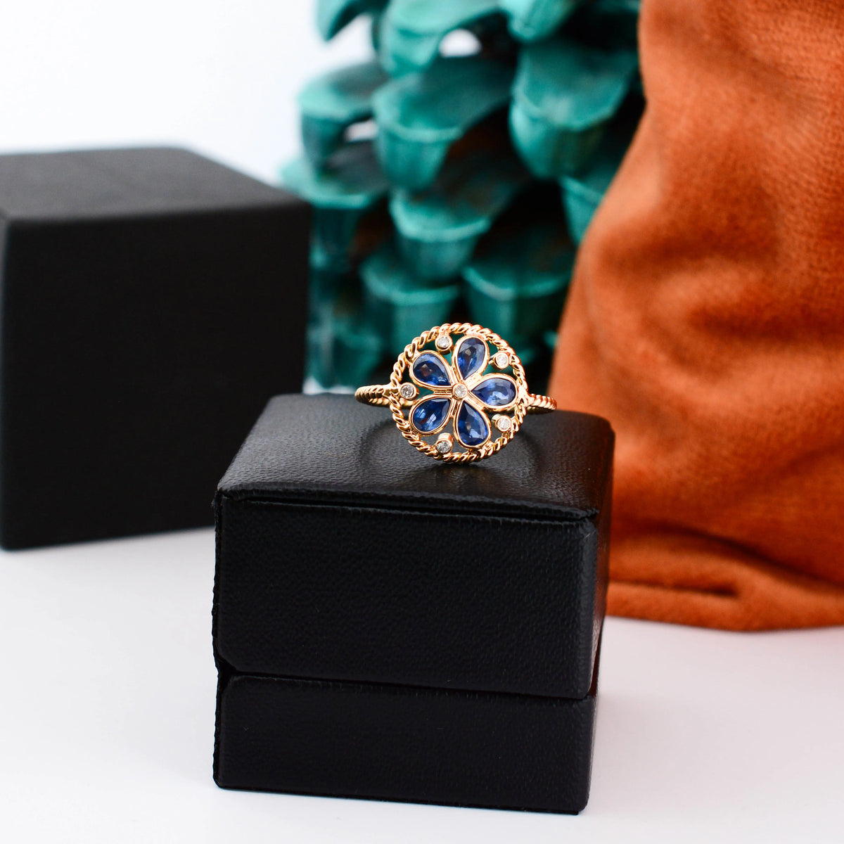 18K gold flower cluster ring with blue sapphire petals and a center diamond