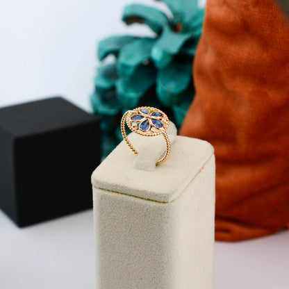 18K gold flower cluster ring with blue sapphire petals and a center diamond