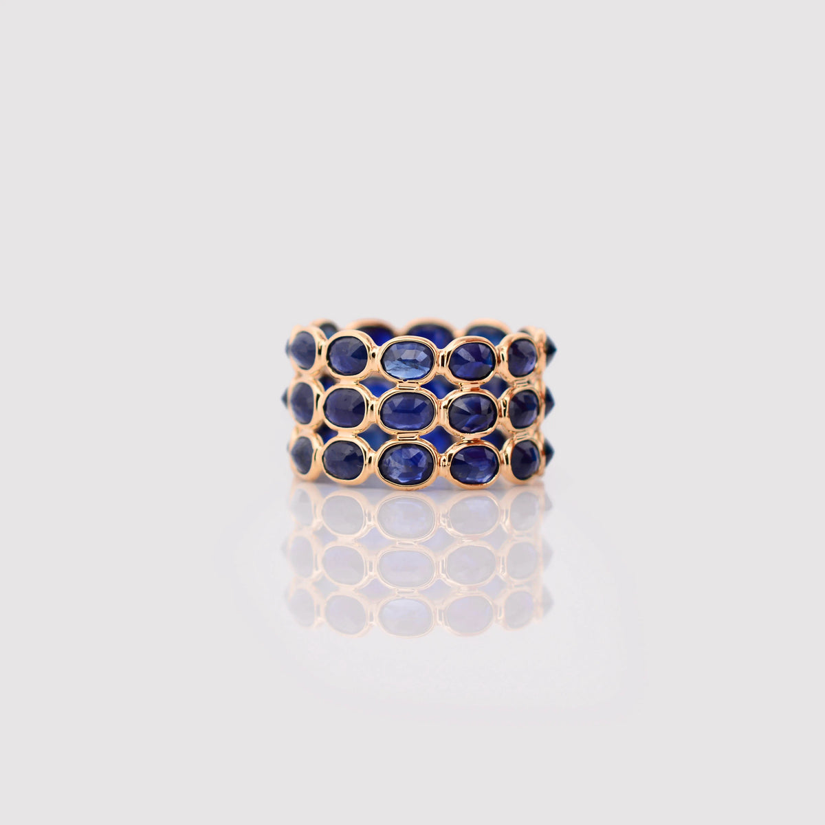 18K gold wide cocktail ring with three rows of bezel-set blue sapphires