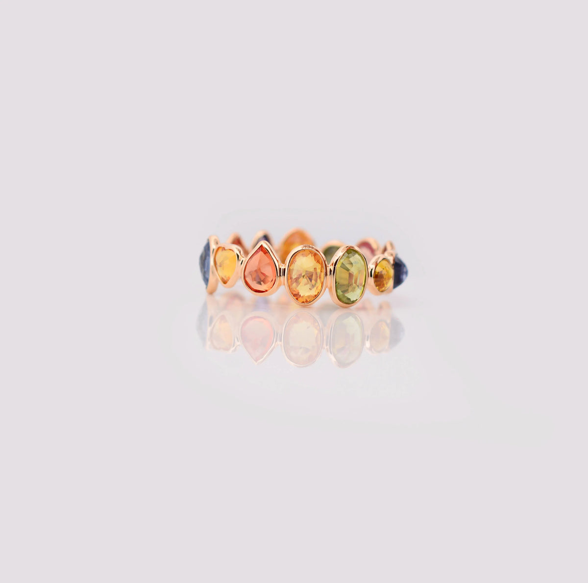 18K gold eternity ring with mixed-cut rainbow sapphire stones