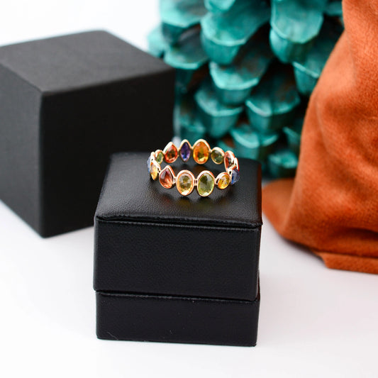 18K gold eternity ring with mixed-cut rainbow sapphire stones