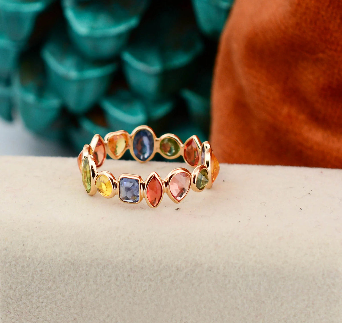 18K gold eternity ring with mixed-cut rainbow sapphire stones