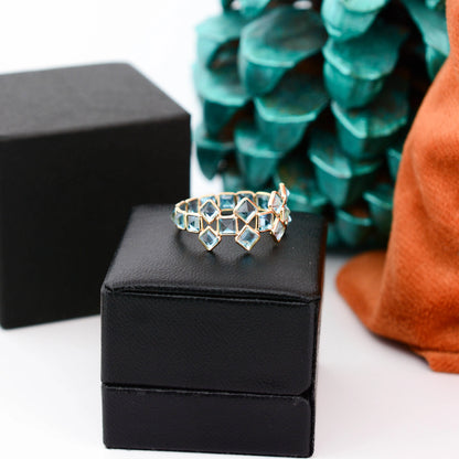 18K gold eternity ring with Swiss blue topaz in a mosaic checkerboard pattern