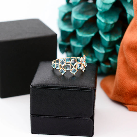 18K gold eternity ring with Swiss blue topaz in a mosaic checkerboard pattern