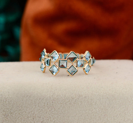 18K gold eternity ring with Swiss blue topaz in a mosaic checkerboard pattern