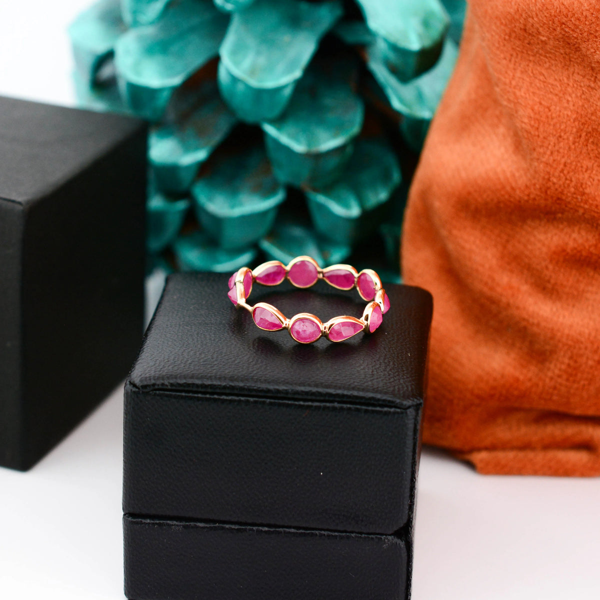 18K gold eternity ring with alternating round and pear-cut rubies