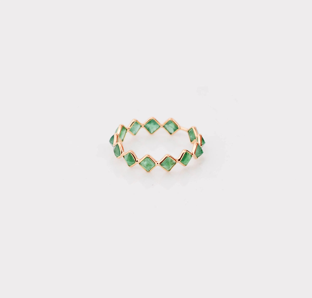 18K gold eternity ring with square and kite-cut emeralds in a zigzag pattern