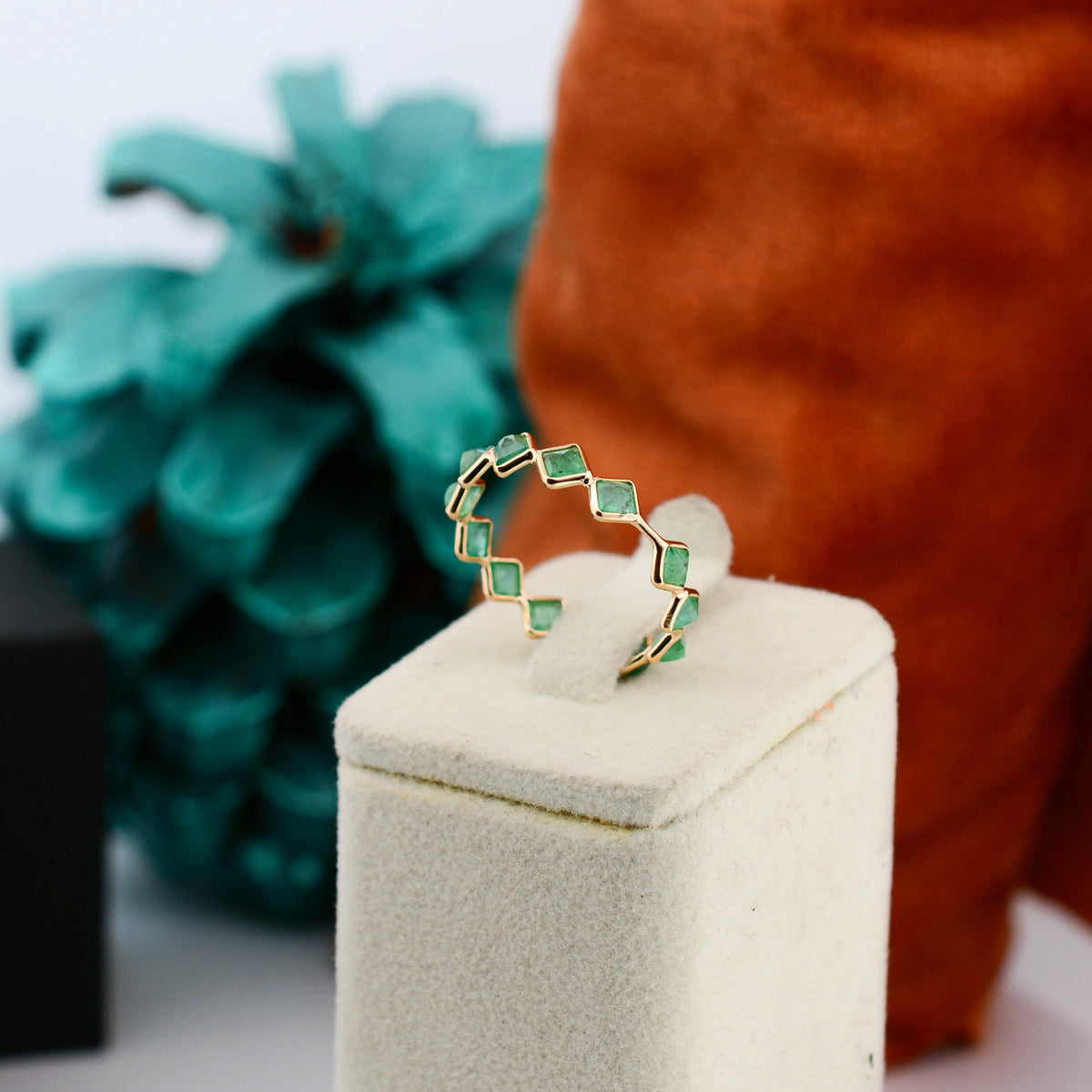 18K gold eternity ring with square and kite-cut emeralds in a zigzag pattern