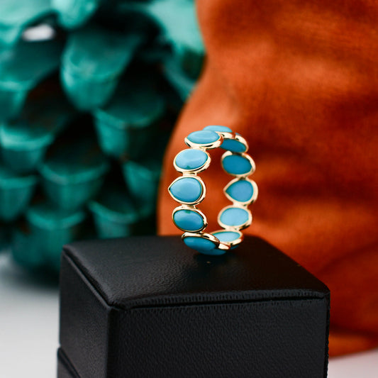 18K gold eternity ring with bezel-set pear and oval turquoise cabochons