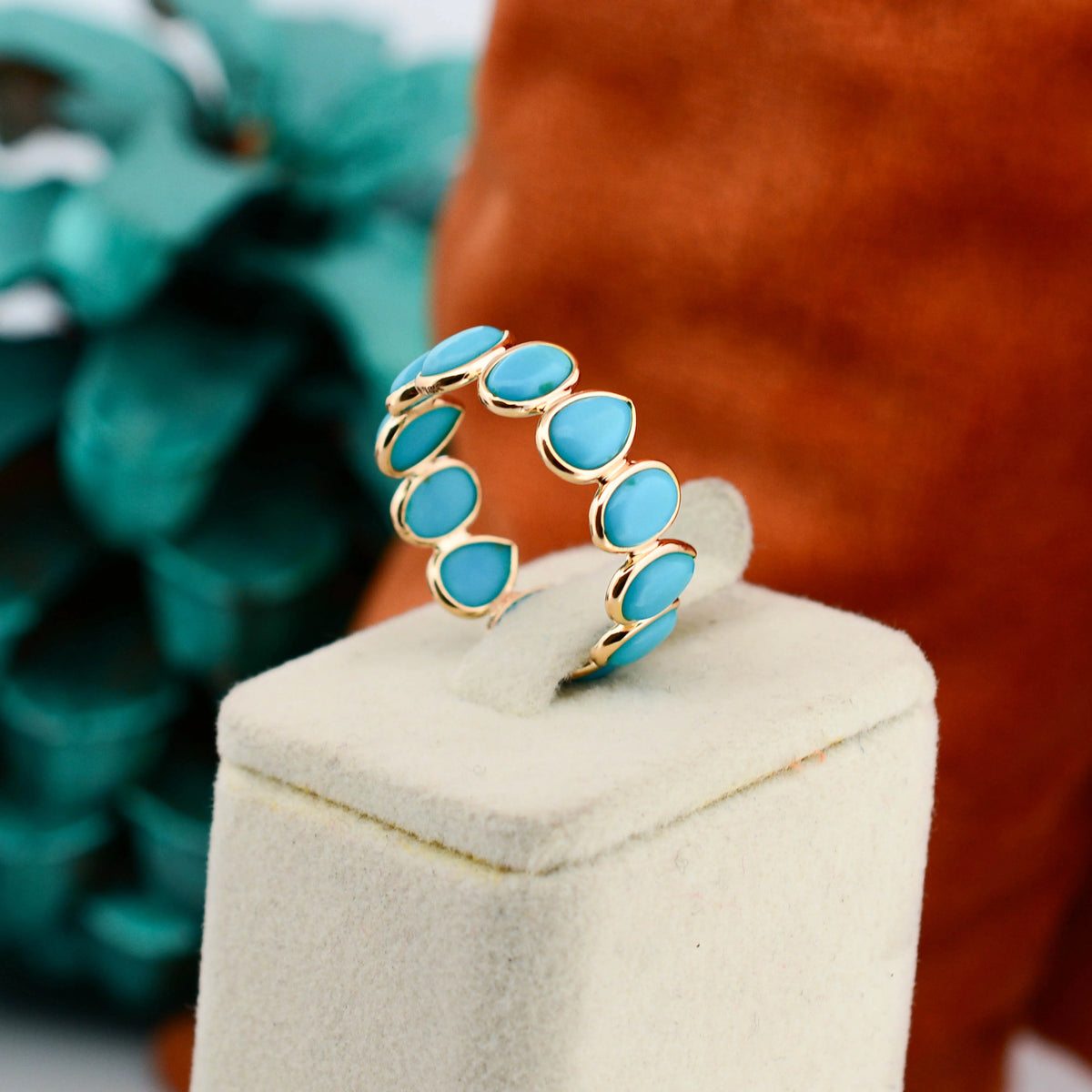 18K gold eternity ring with bezel-set pear and oval turquoise cabochons