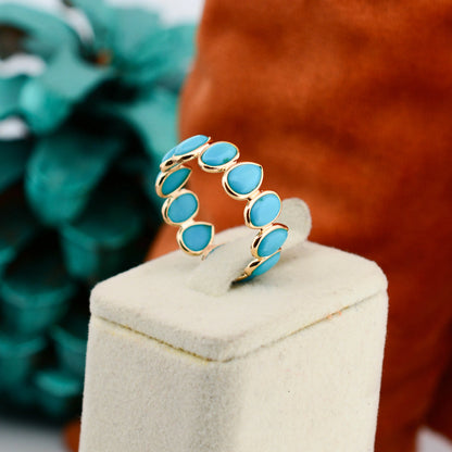 18K gold eternity ring with bezel-set pear and oval turquoise cabochons