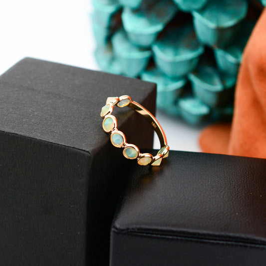 18K gold eternity ring with bezel-set opals and diamond accents