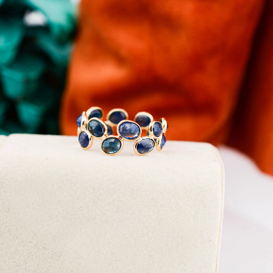 18K gold eternity ring with bezel-set oval-cut blue sapphires
