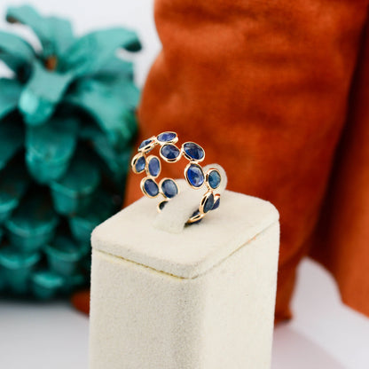 18K gold eternity ring with bezel-set oval-cut blue sapphires