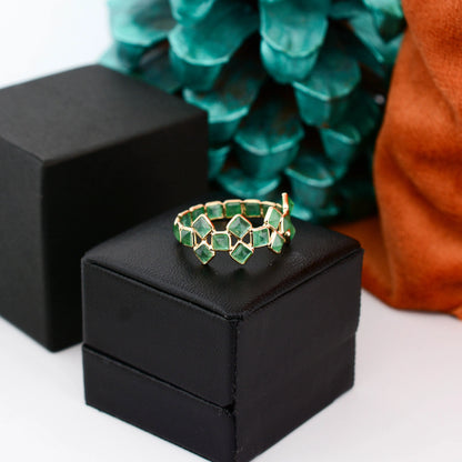 18K gold eternity ring with square-cut emeralds in a checkerboard lattice pattern