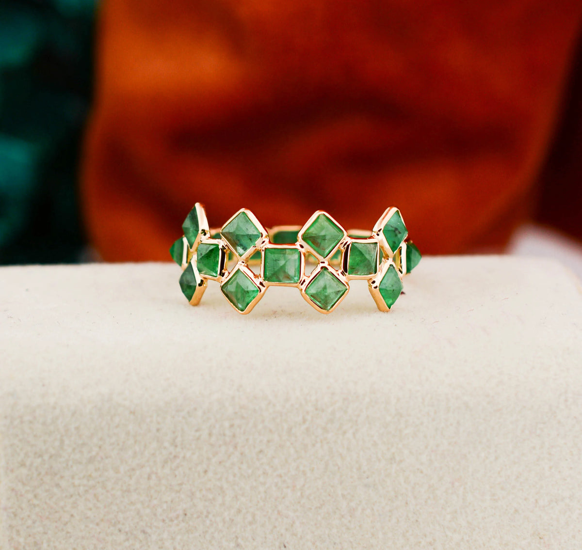 18K gold eternity ring with square-cut emeralds in a checkerboard lattice pattern