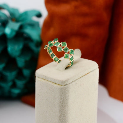 18K gold eternity ring with square-cut emeralds in a checkerboard lattice pattern