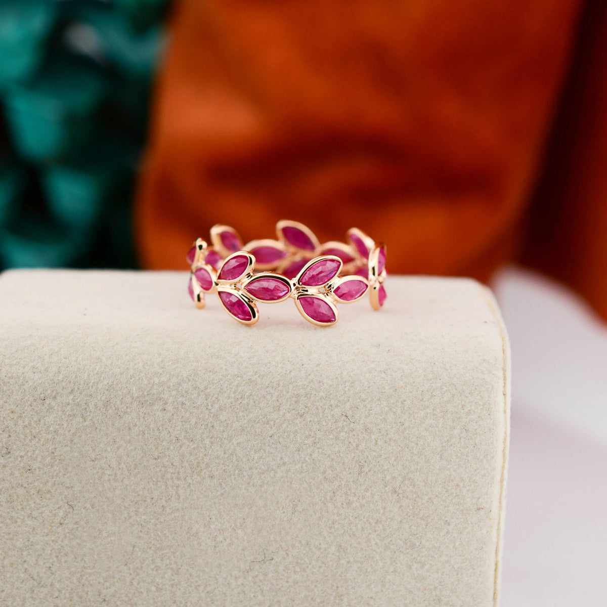 18K gold eternity ring with marquise-cut rubies in a floral vine design