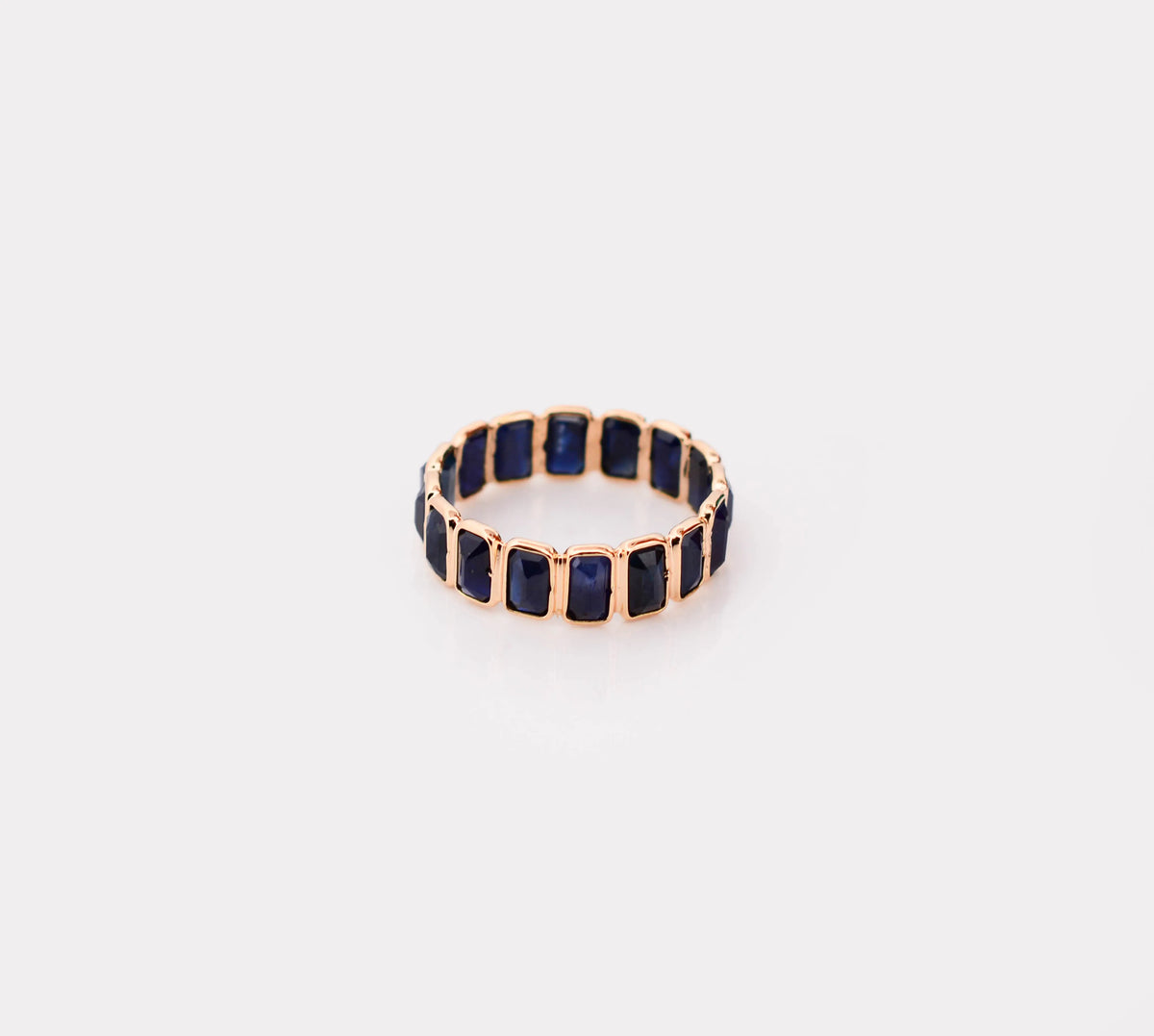 18K gold eternity ring with bezel-set emerald-cut blue sapphires